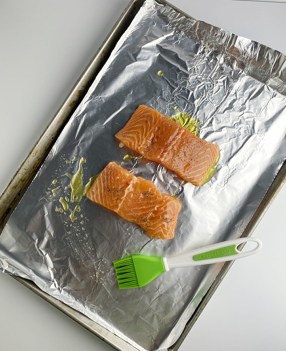 Basted salmon on baking sheet with foil.