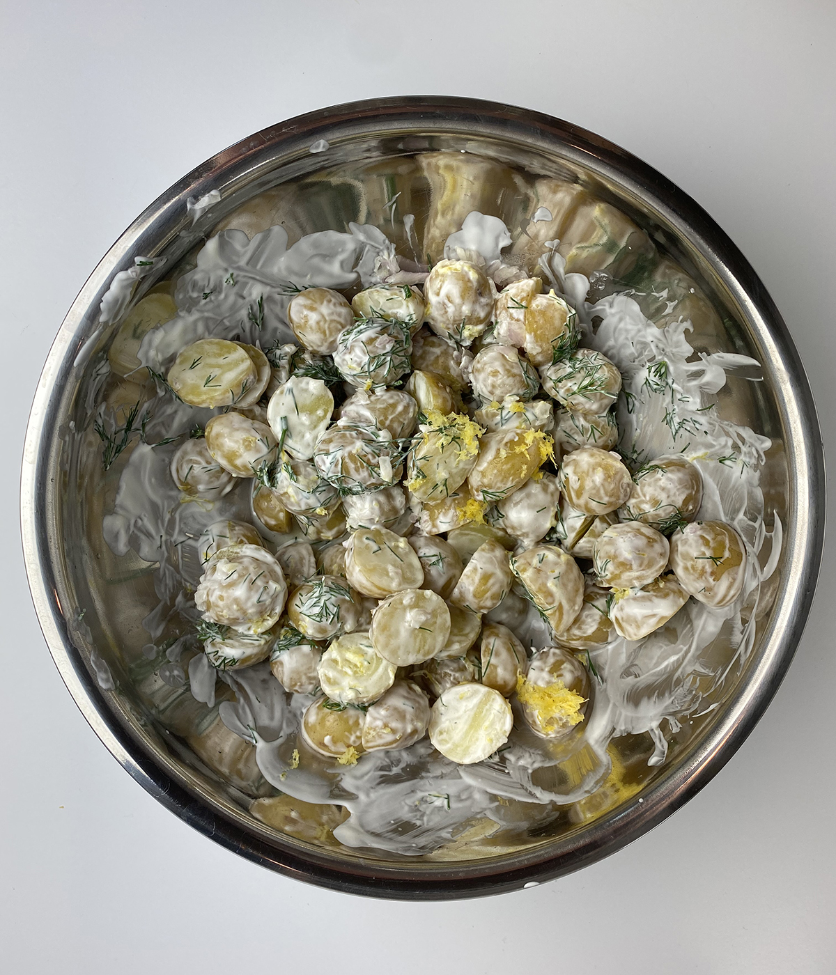 Sour cream potato salad mixed in a bowl.