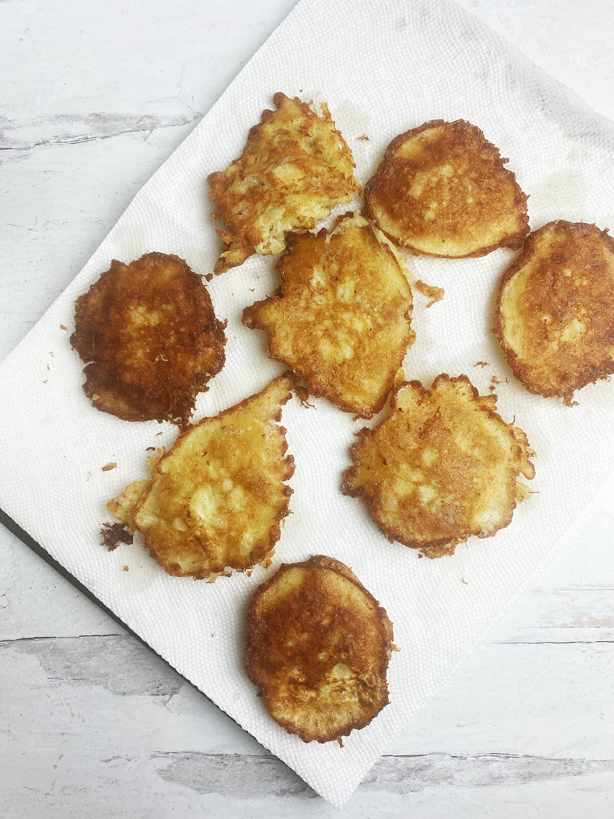 Clam fritters draining on paper towels.