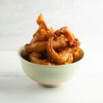 Pancake batter onion rings in a bowl.