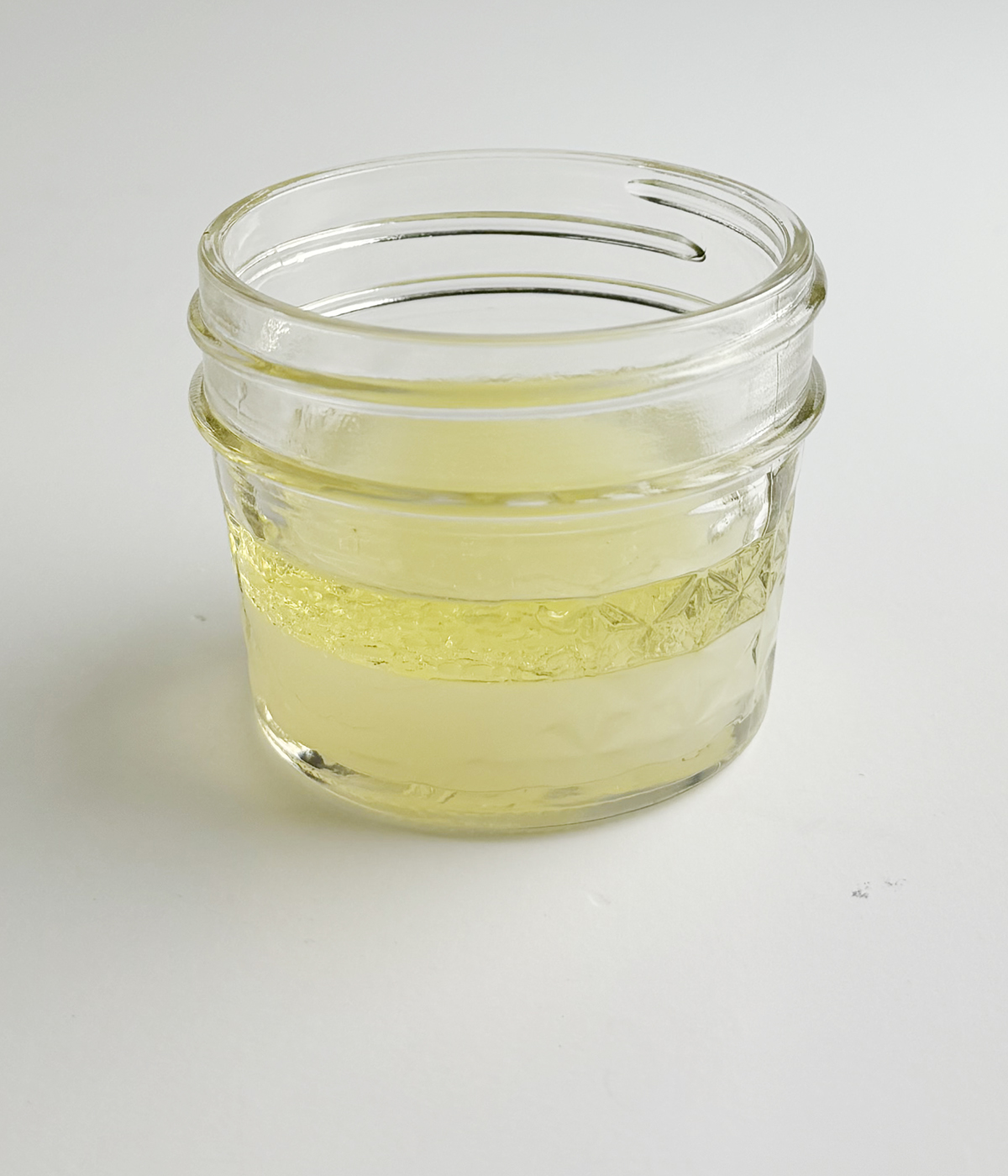 Mason jar with salad dressing on a counter.