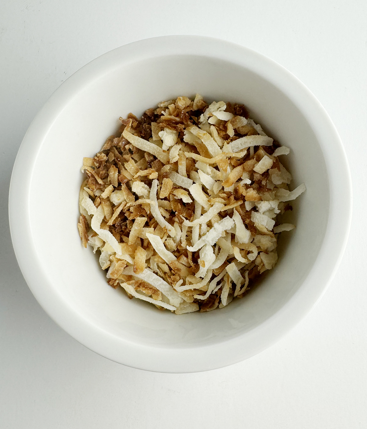 Toasted coconut flakes in a bowl.