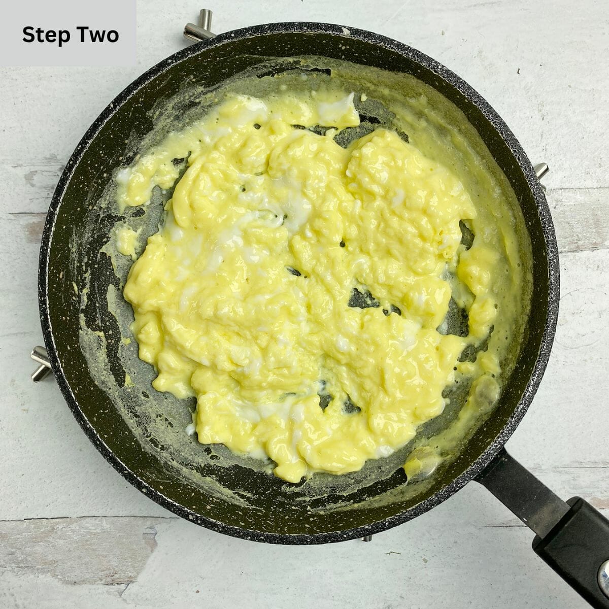 Cooked scrambled eggs in a skillet.