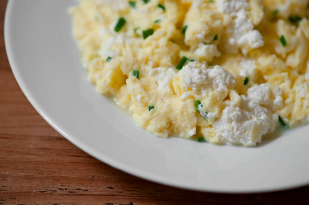 Soft scrambled eggs with ricotta on a plate.