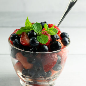 A bowl of mimosa fruit salad with a spoon.