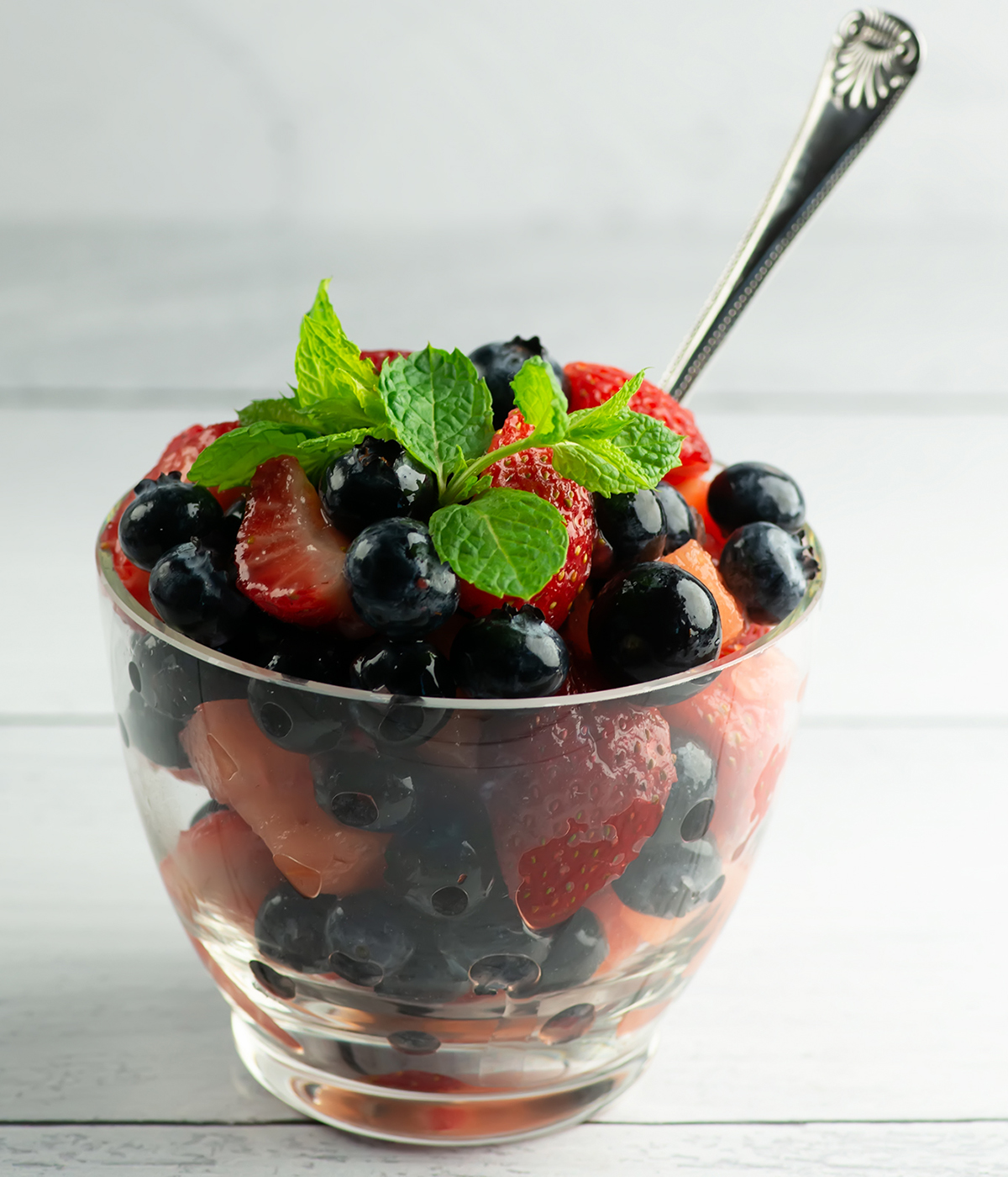 A bowl of mimosa fruit salad with a spoon.