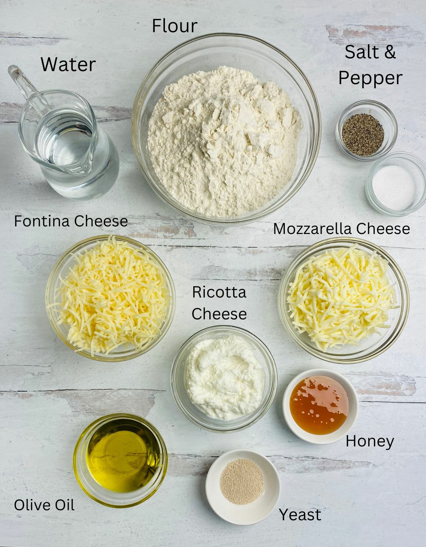 Honey cheese pizza ingredients on a wooden counter.
