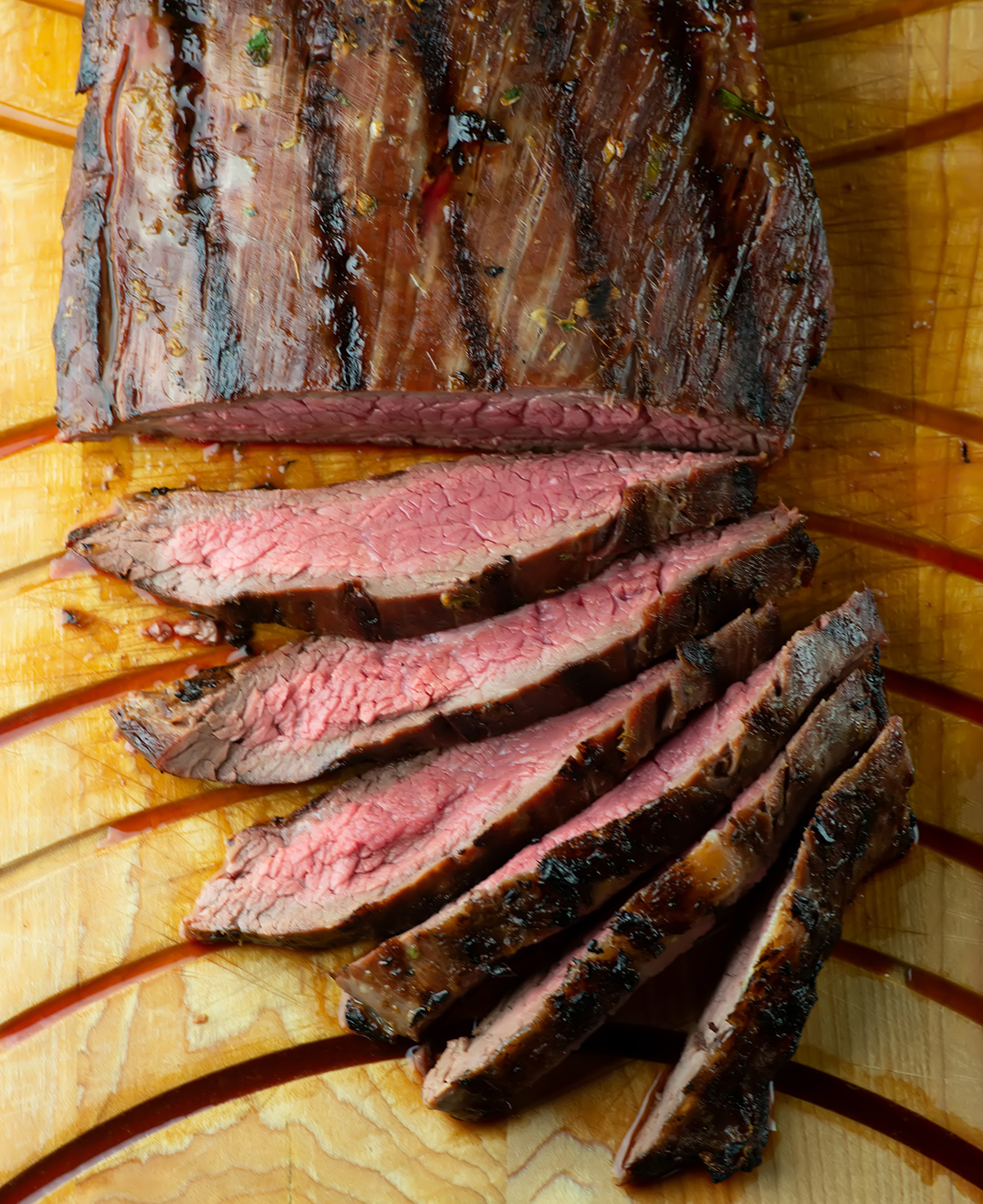 Sliced rum steak on a cutting board.