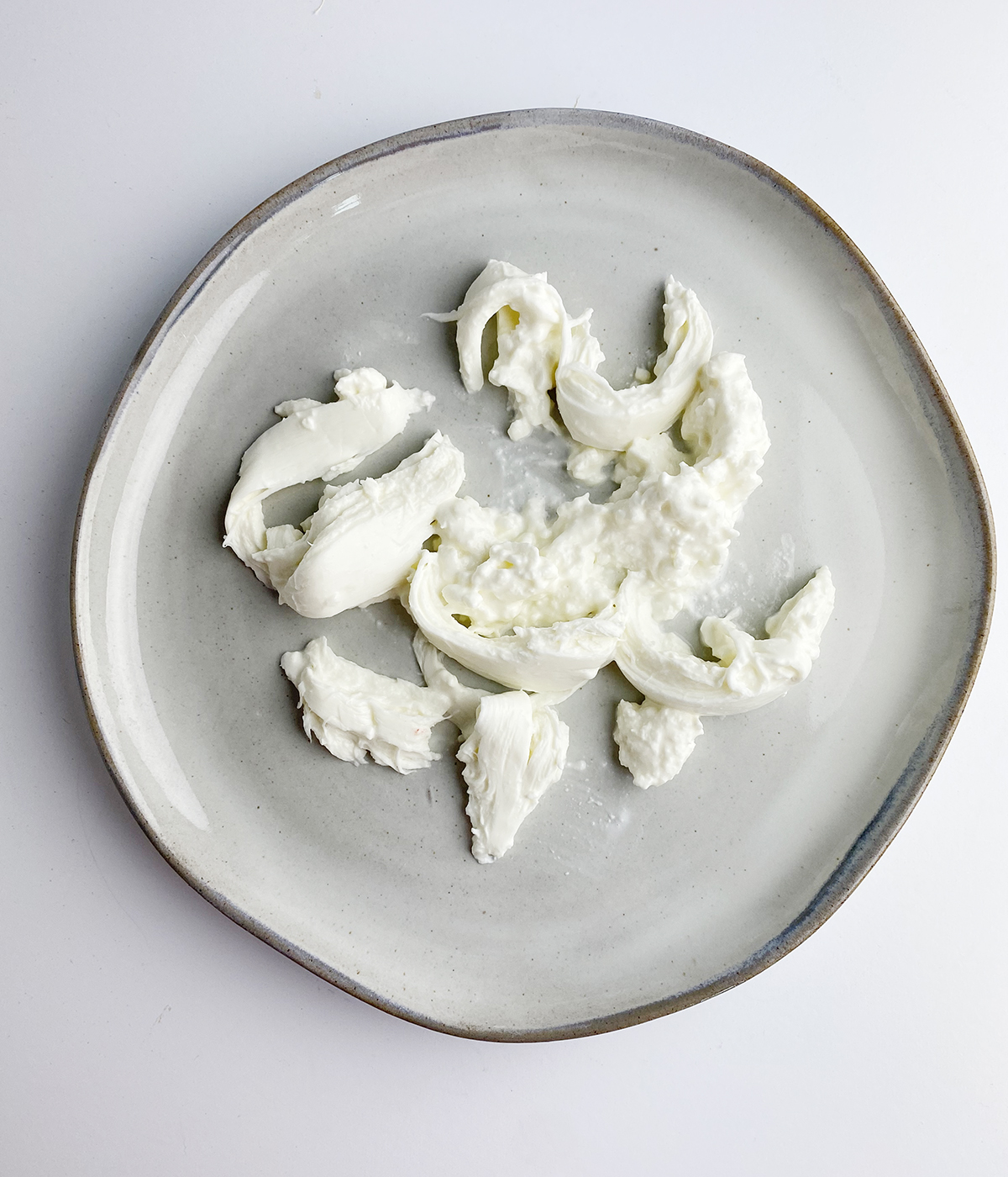 Torn mozzarella on a plate.