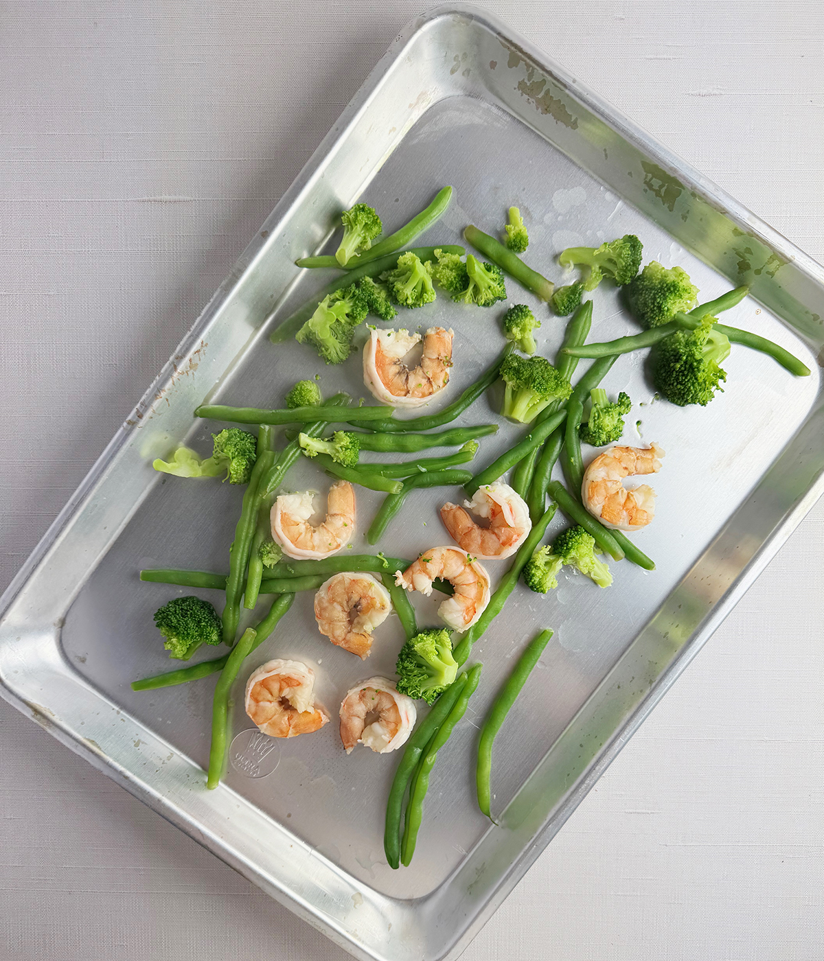 Vegetables and shrimp on a baking pan.