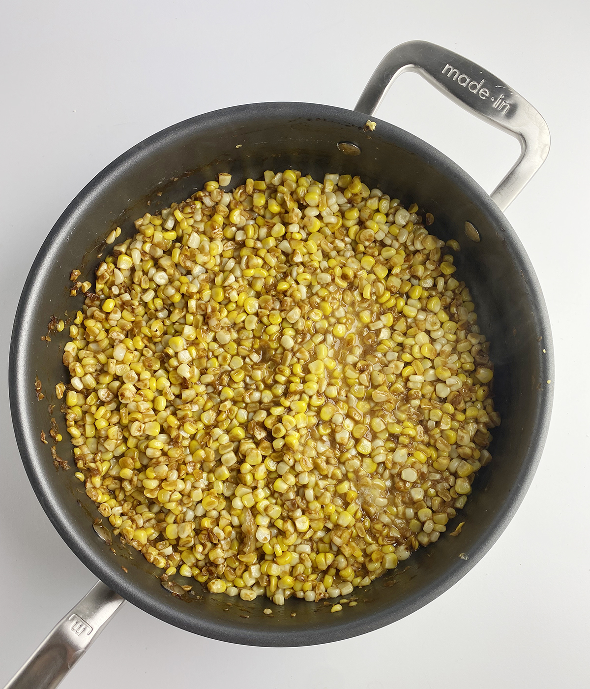 Cooked buttered skillet corn in a skillet.