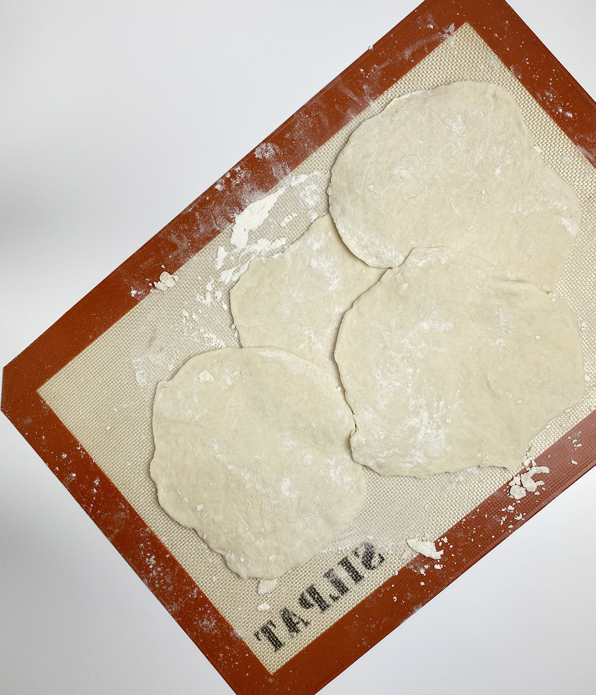 Rolled out flatbread on a silicone mat.