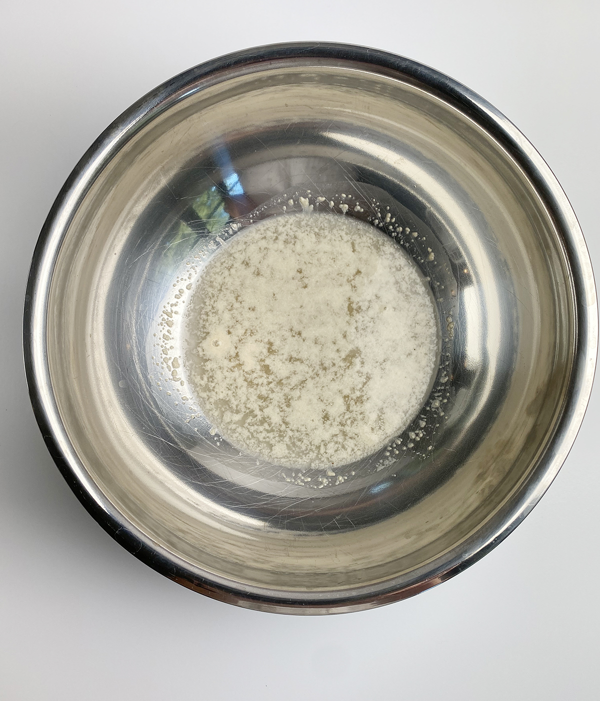 Yeast and water in a metal bowl.