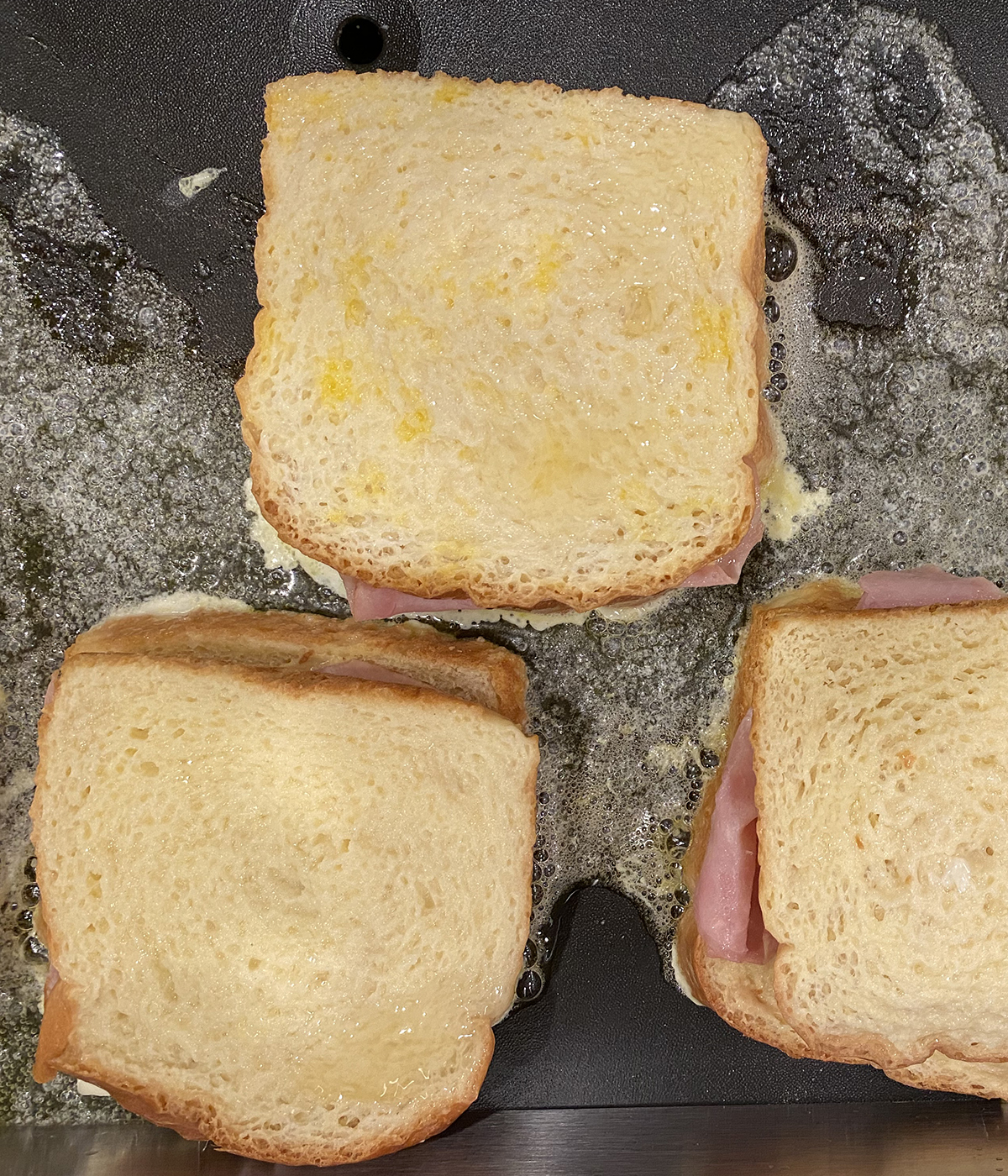 French toast grilled cheese sandwiches cooking on a griddle