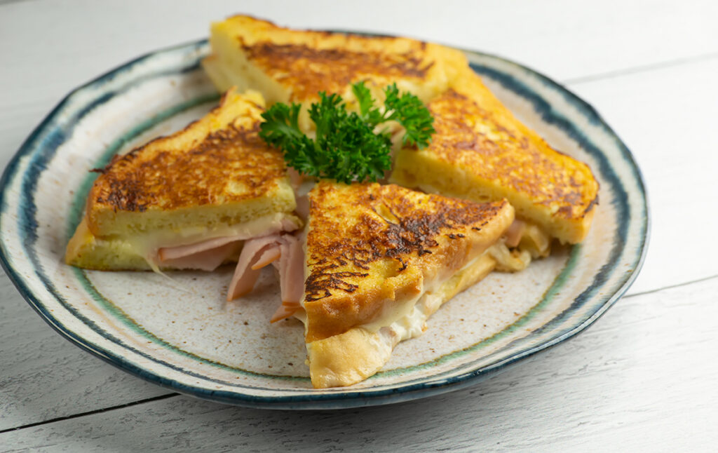 French toast grilled ha and cheese on a plate with parsley.