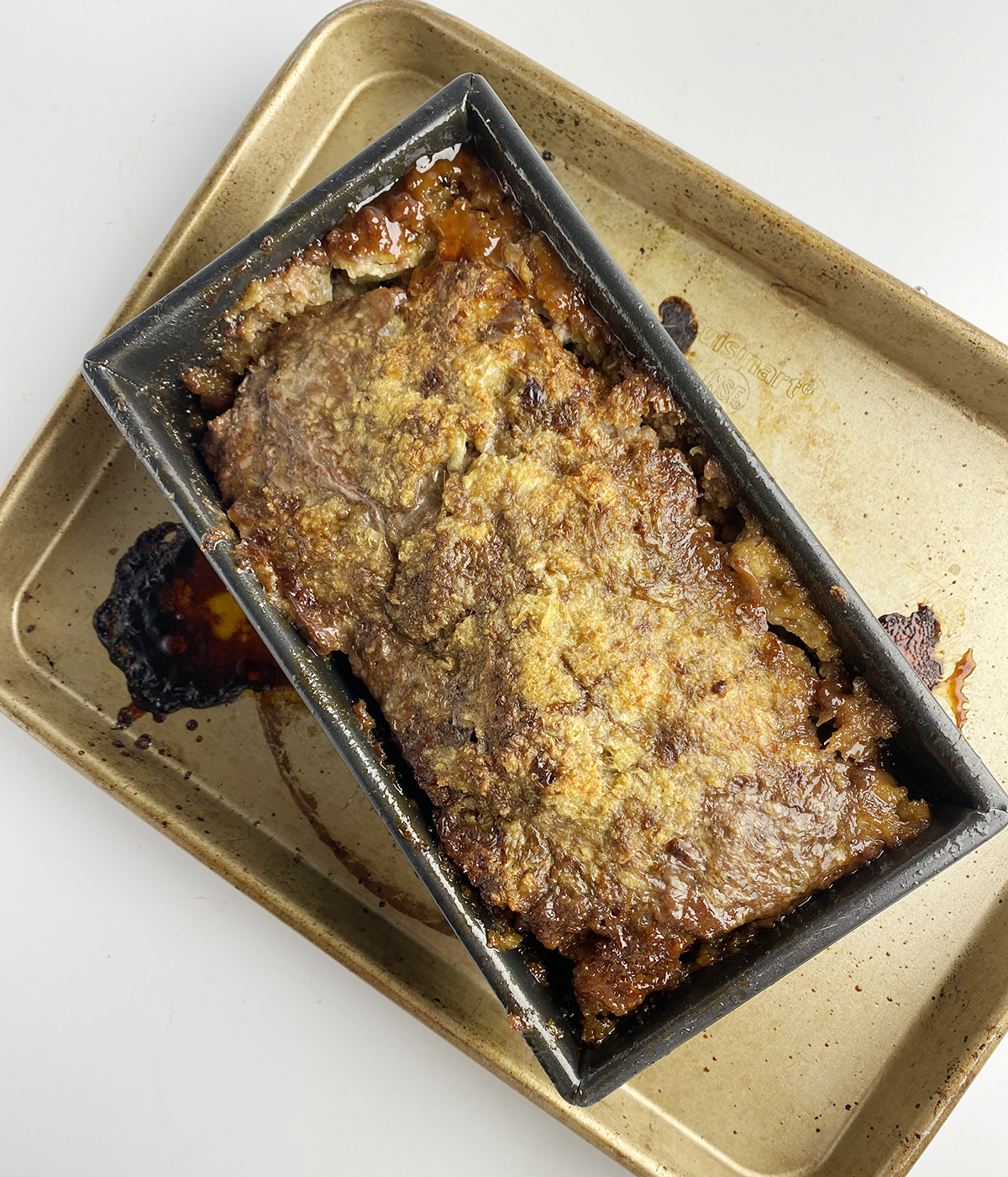 Baked brown sugar meatloaf on a baking tray.