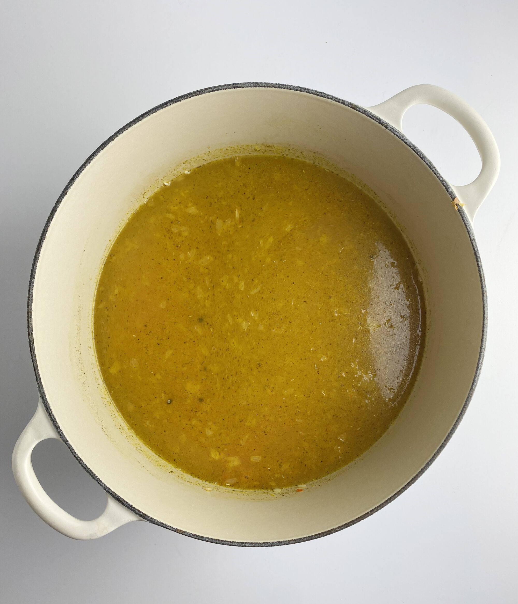 Chicken broth and rice in a pot.