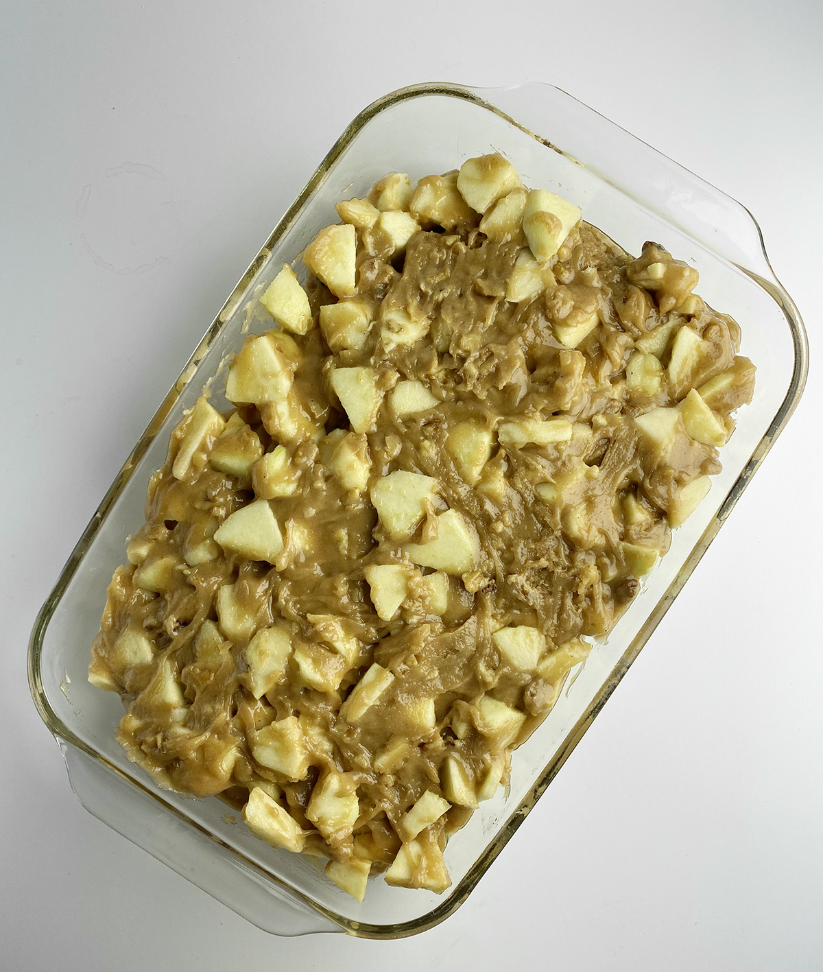Caramel apple cake in a casserole dish ready for the oven.