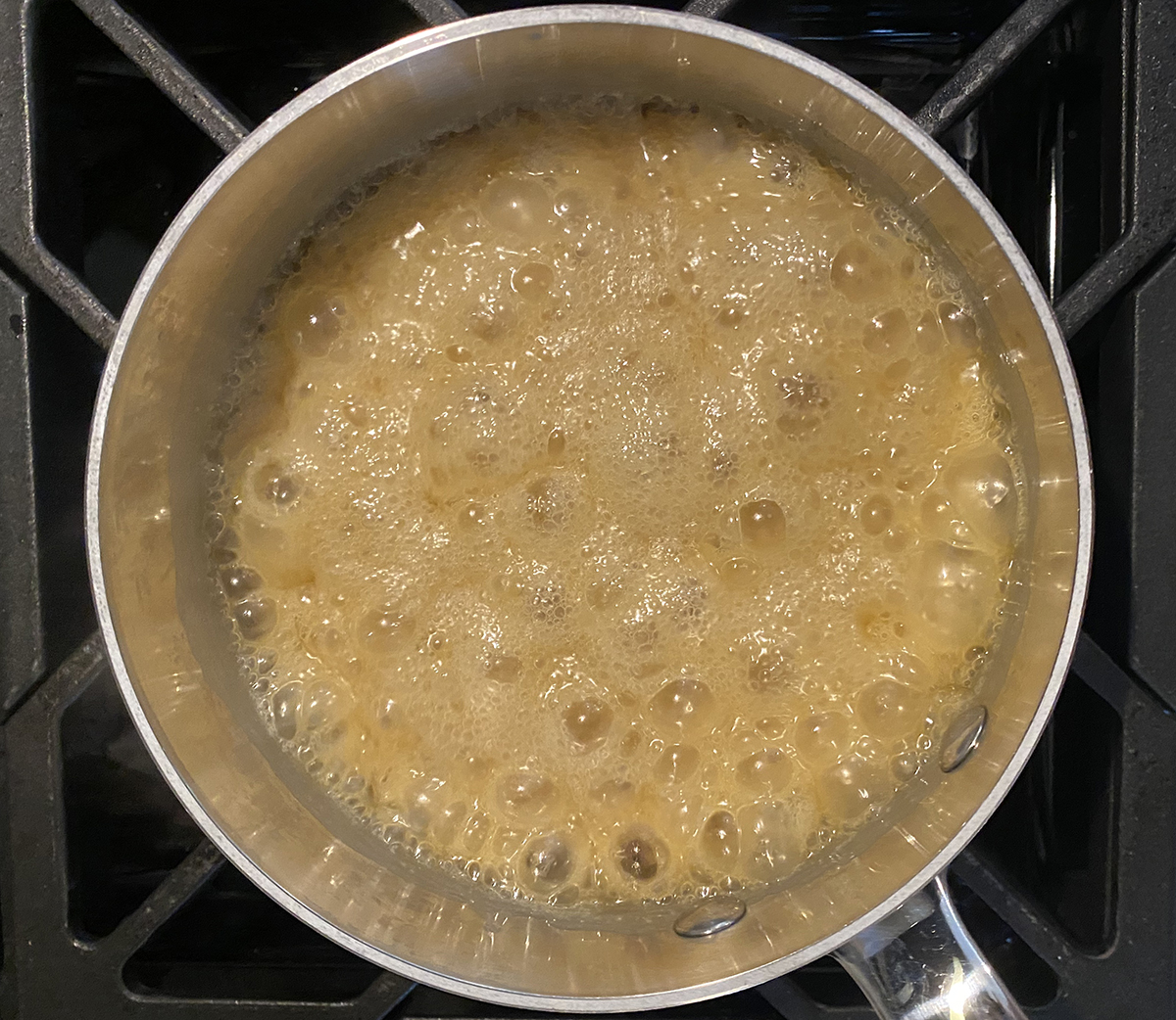 Boiling caramel sauce in a pot.