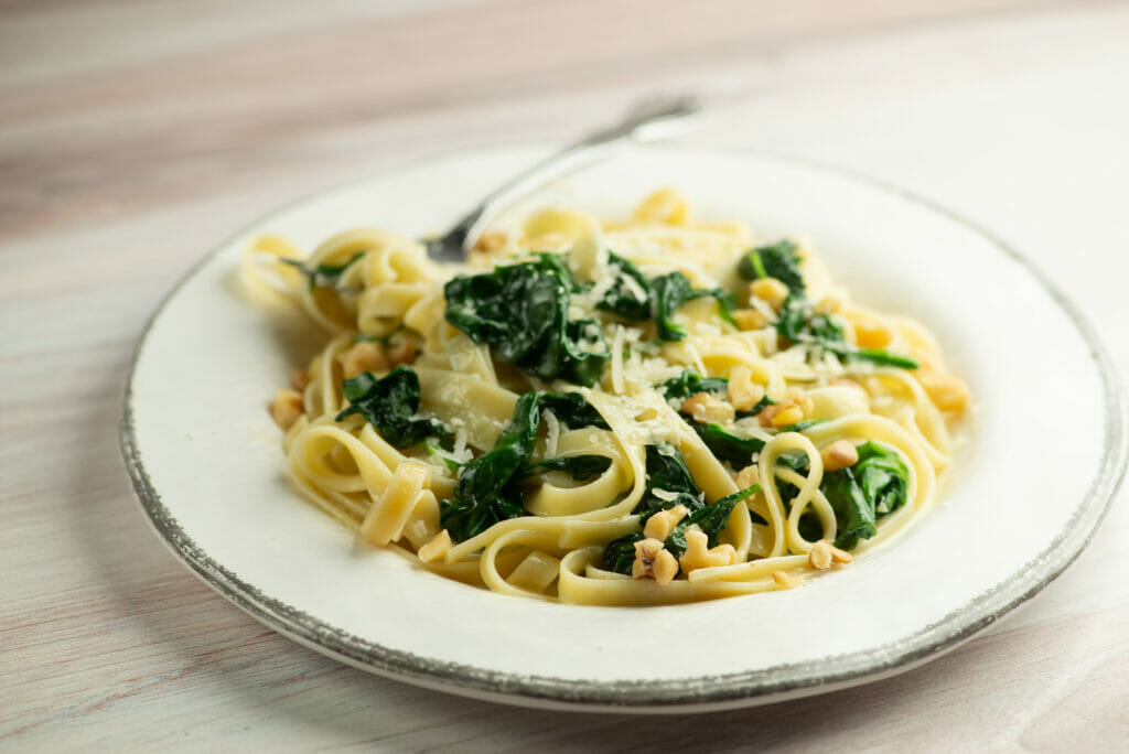 Pasta with creamed spinach sauce on a plate.