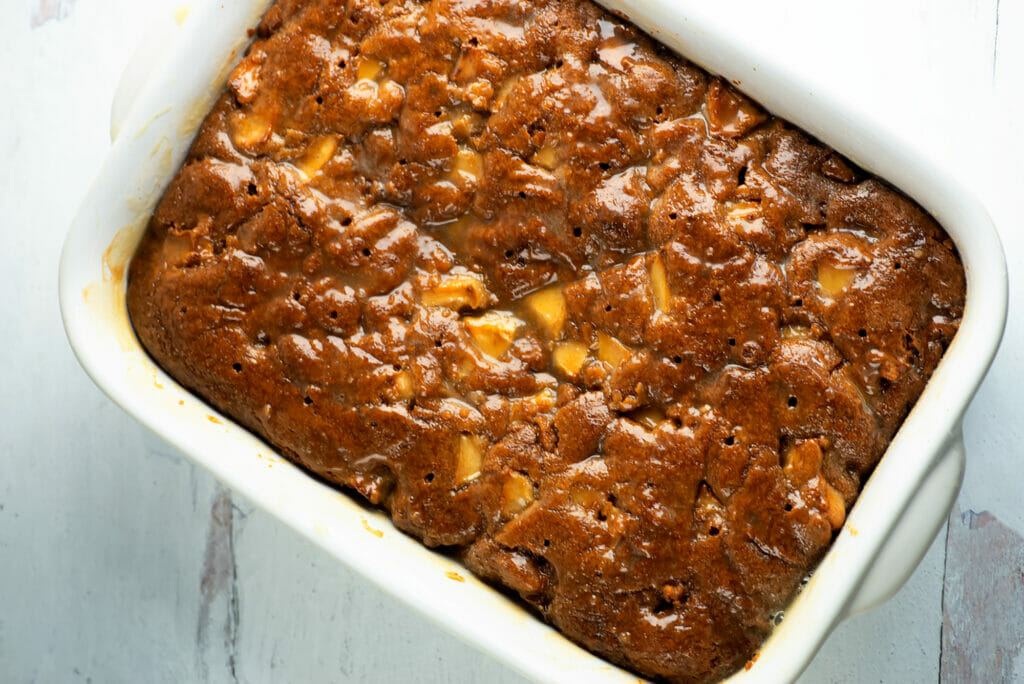 Sticky caramel apple cake in a casserole dish.