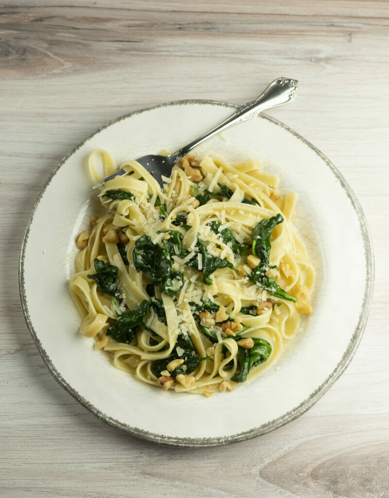 Pasta with creamed spinach sauce on a plate.