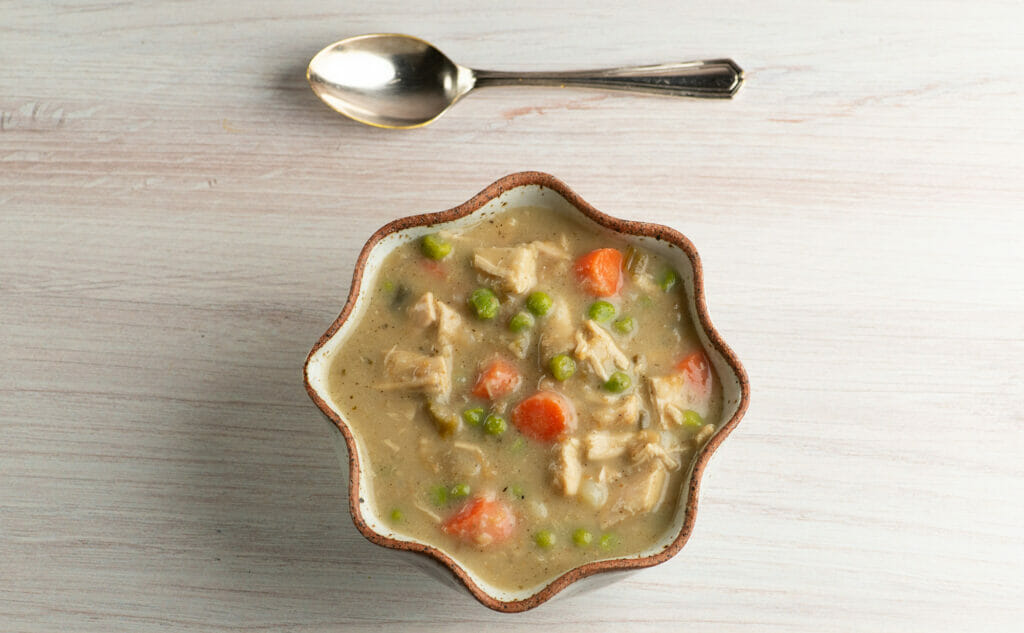 Thanksgiving leftovers soup in a bowl with a spoon.