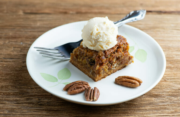Pecan pie square on a plate with a fork.