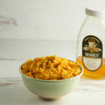 Mashed Honey Butternut Squash in a bowl with honey.