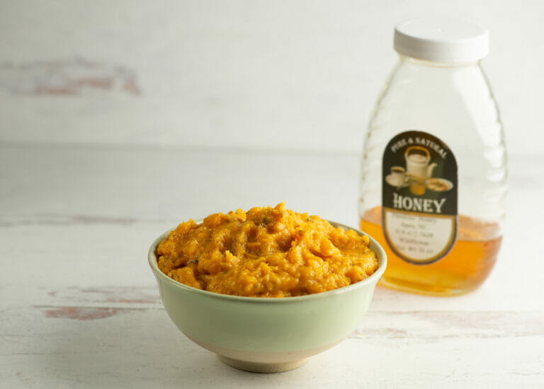 Mashed Honey Butternut Squash in a bowl with honey.