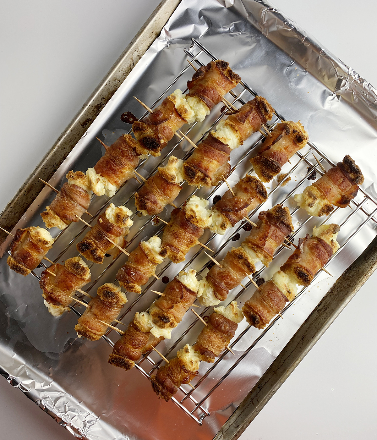 Bacon cheese rolls out of the oven on a rack.
