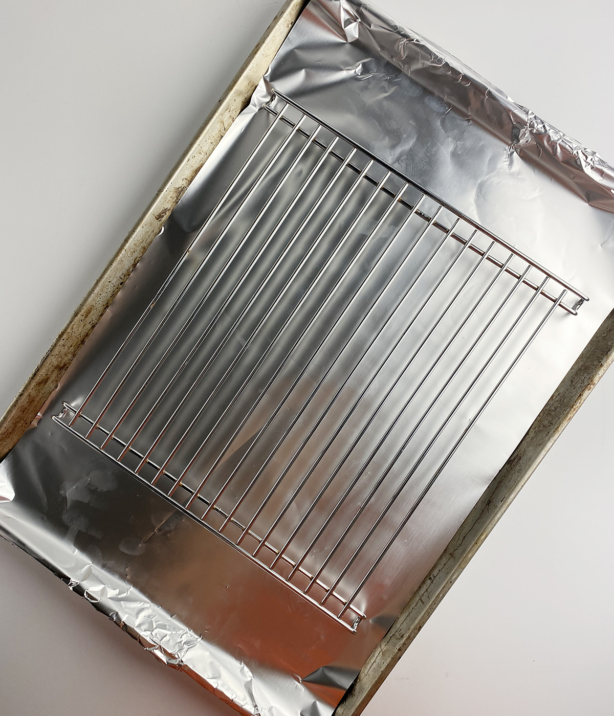 Baking pan lined with foil and with a cooling rack on top.