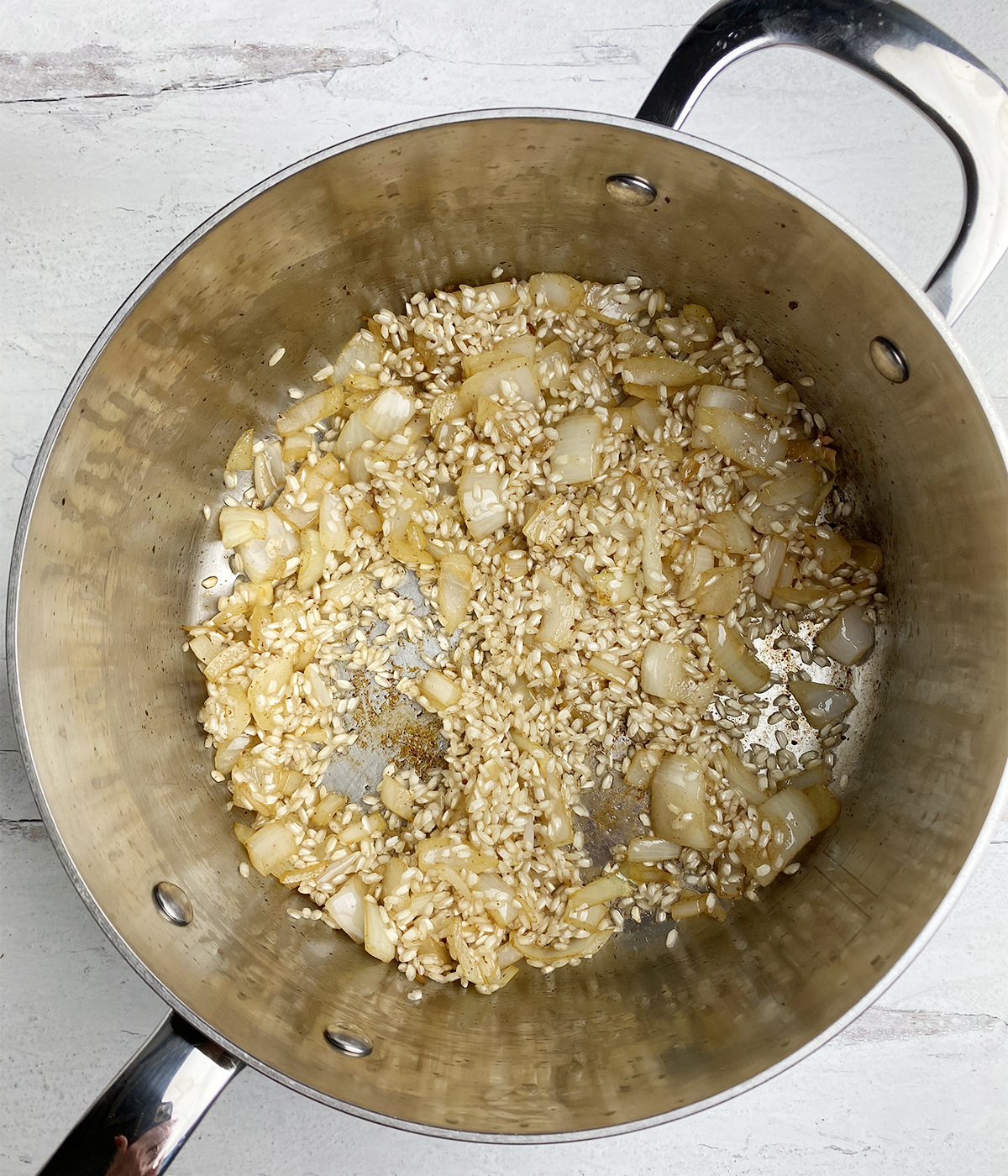 Rice and onion cooking in bacon drippings.
