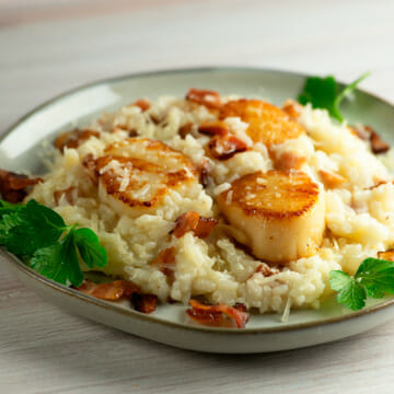 Bacon scallop risotto on a plate.
