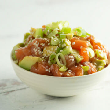 Chopped Salmon Tartare in a bowl on a wooden counter.