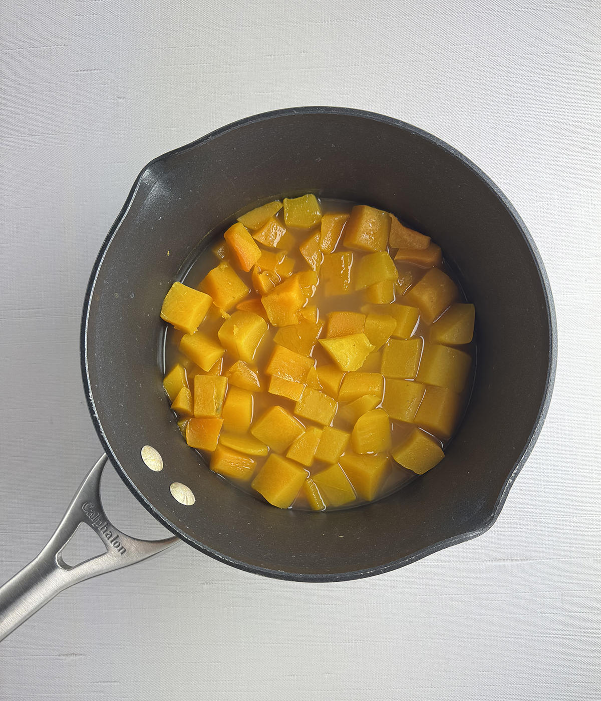 Cooked butternut squash in a pot.