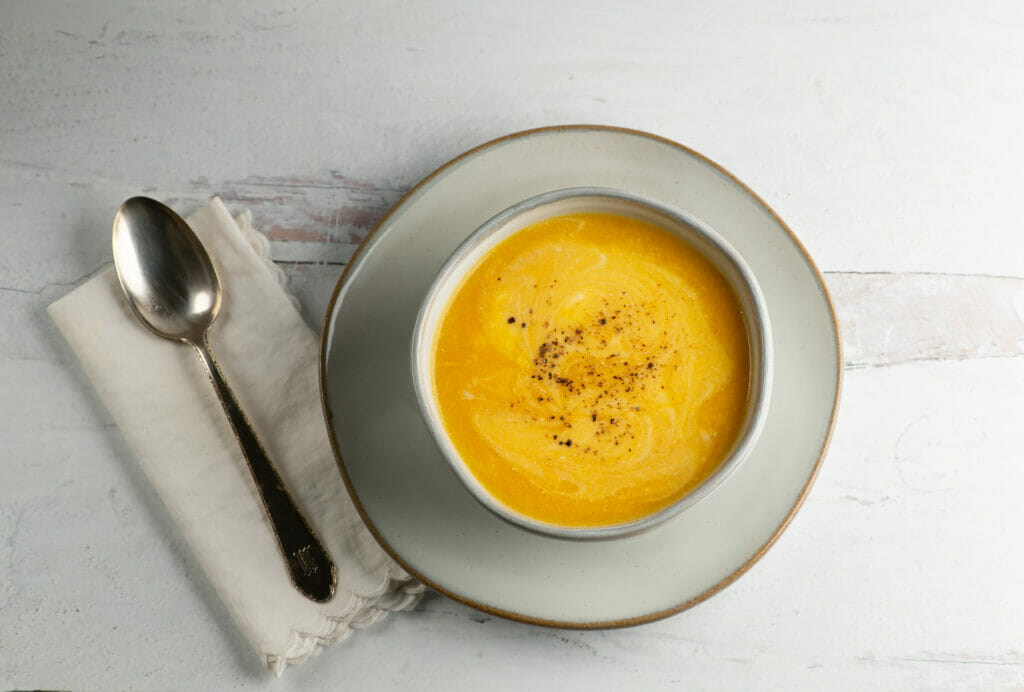 Butternut Cheddar Soup in a bowl with a spoon and napkin.