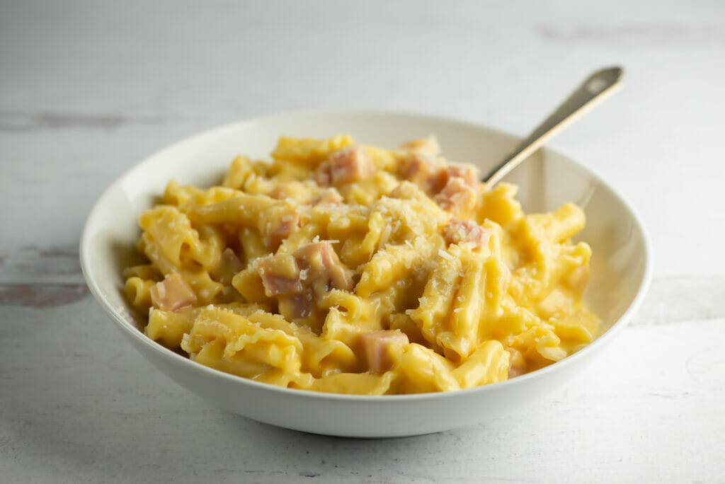 Creamy Ham Macaroni and Cheese in a bowl with a fork.