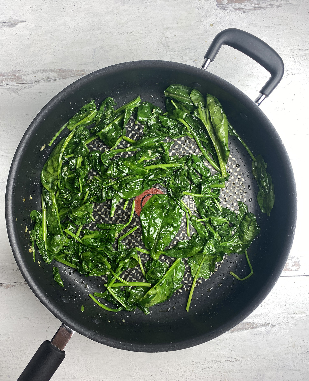 Sauteed spinach in a skillet.