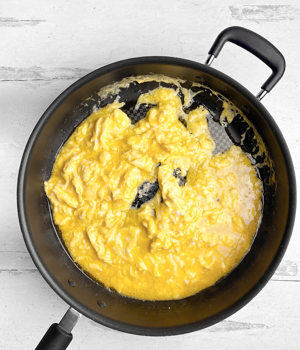 Softly scrambled eggs in pan.