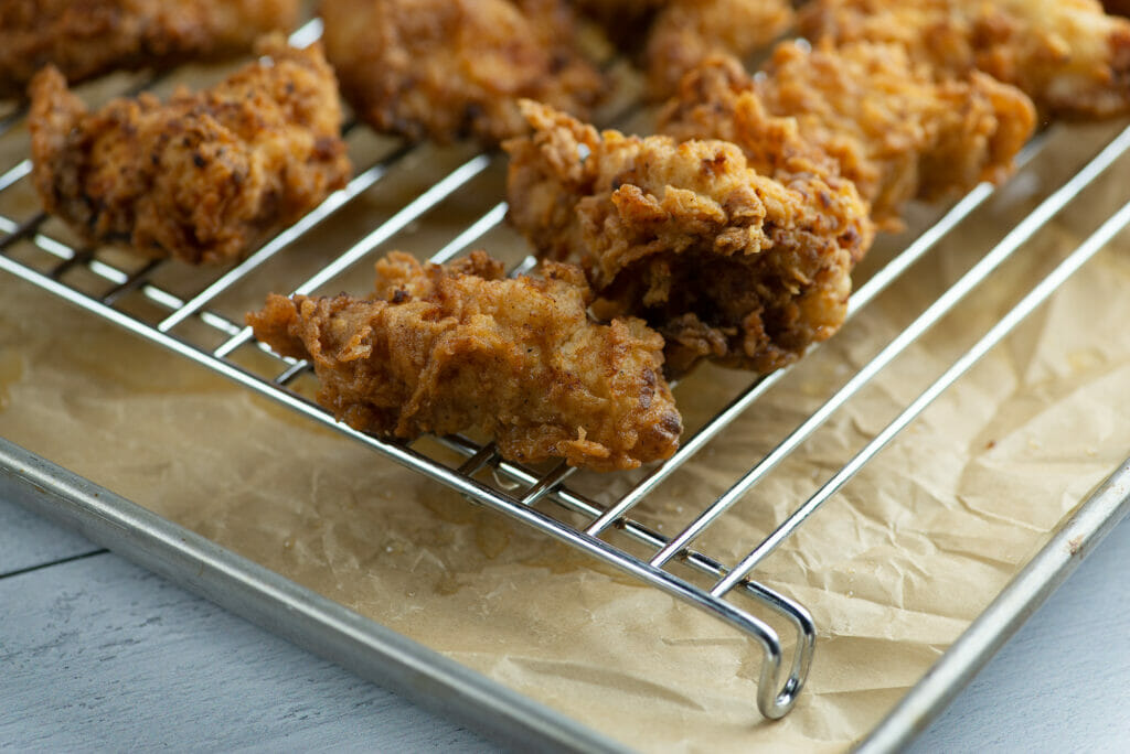 Buttermilk Fried Chicken Tenders cooling on a rack.