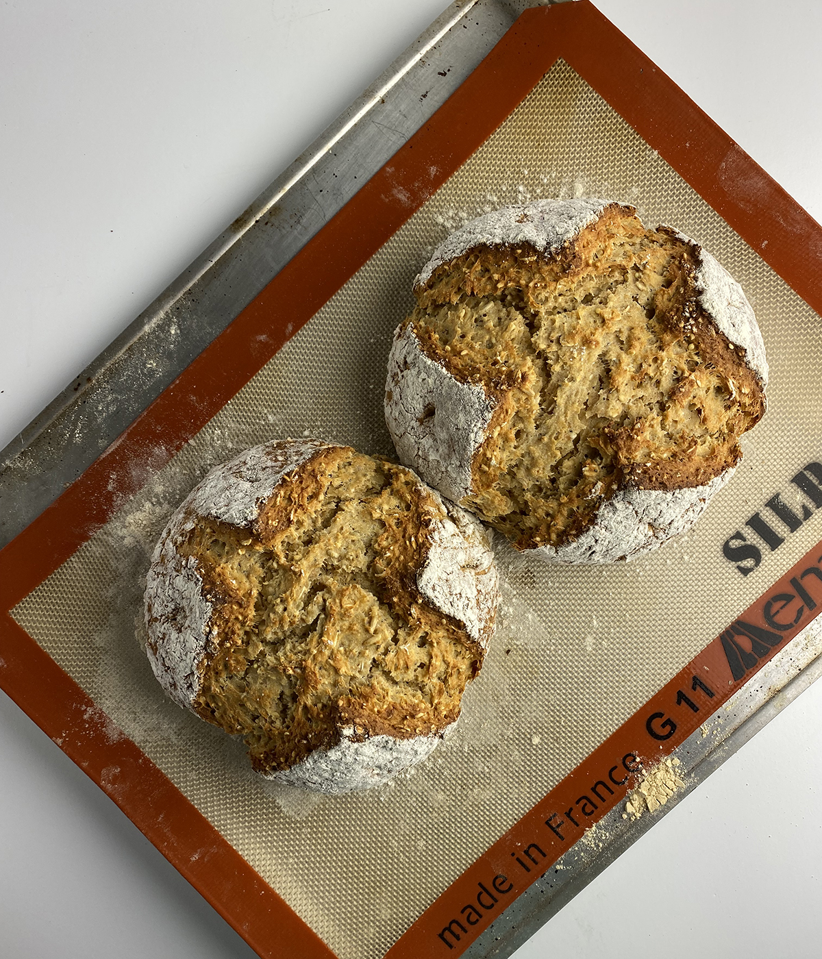Baked irish brown bread on a cookie sheet.