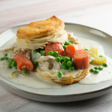 Slow cooker chicken and biscuits on a plate.