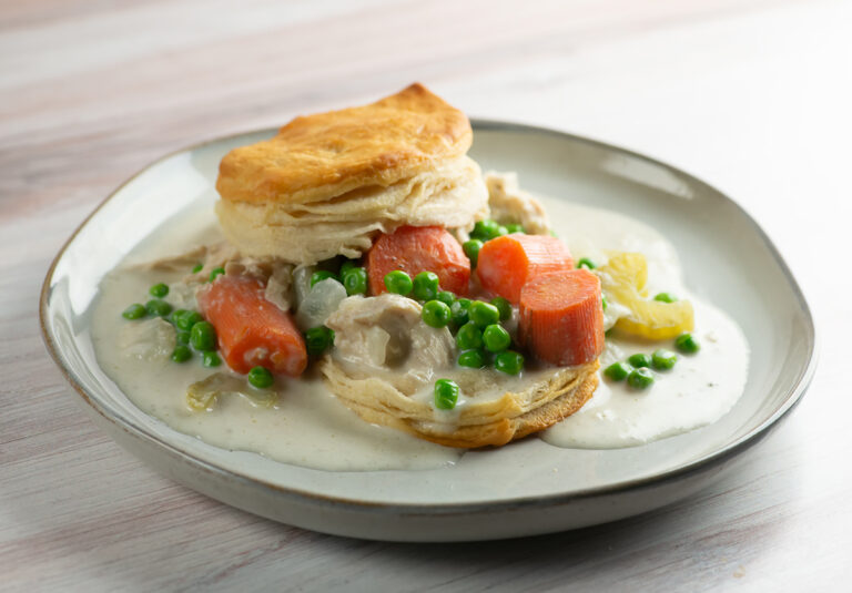 Slow cooker chicken and biscuits on a plate.