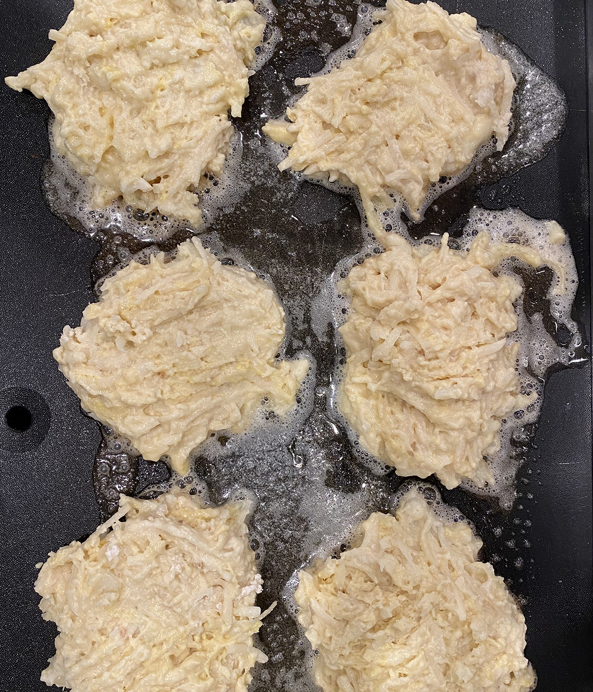 Irish Boxty potatoes cooking on a griddle.