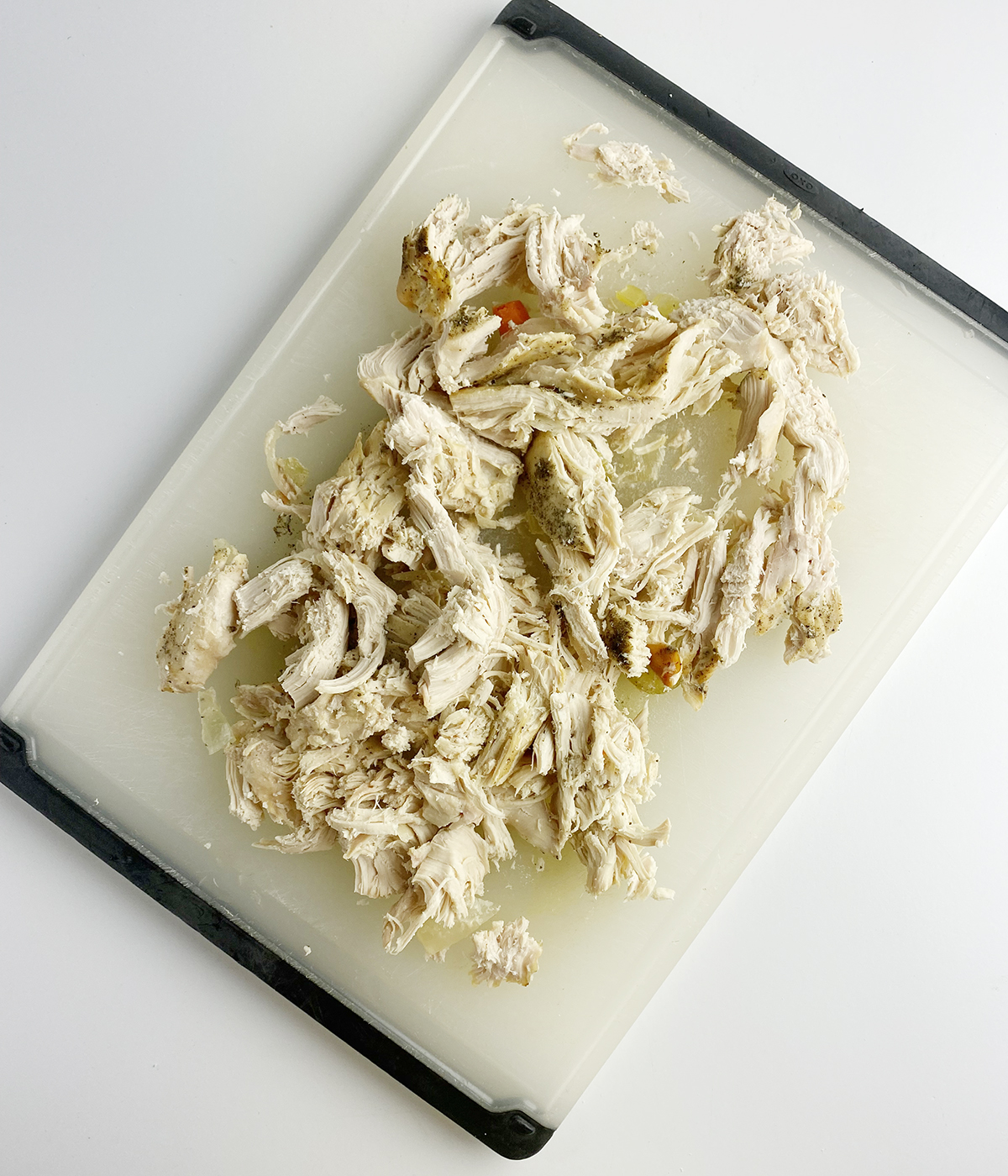 Shredded chicken on a cutting board.