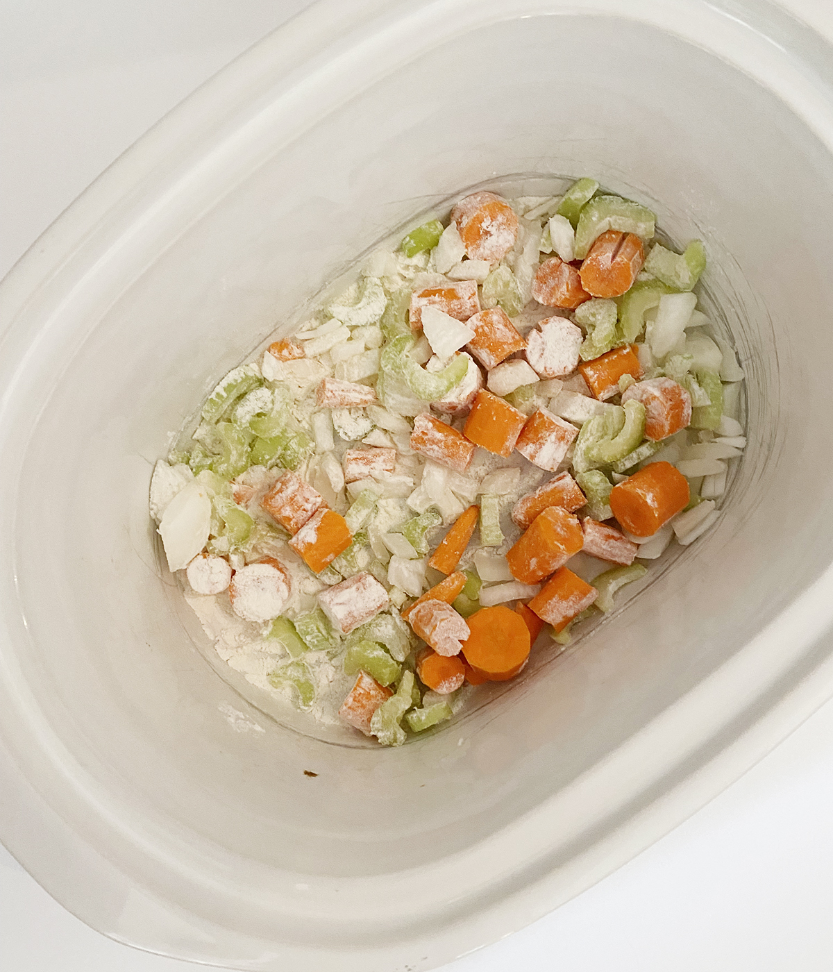Vegetables mixed with flour in the slow cooker.