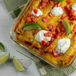 Creamy chicken enchilada casserole on a wooden board.