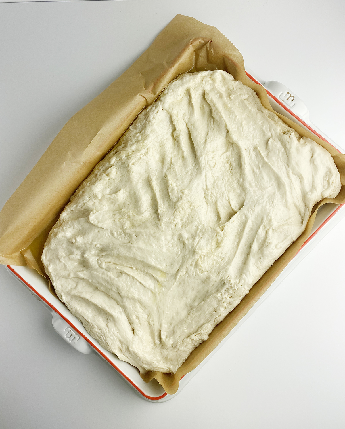 Focaccia dough second rise in a baking pan.