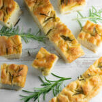 Sliced focaccia on a wooden board.